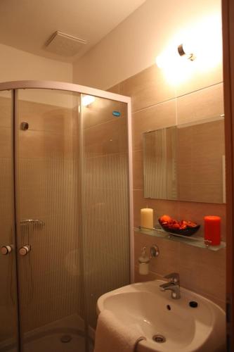 a bathroom with a shower and a sink and a mirror at Stan és Panzió in Balatonalmádi