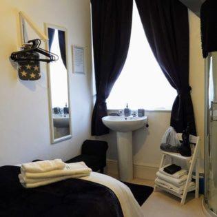 a bedroom with a bed and a sink and a window at Kings Arms Hotel in Holsworthy