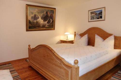 a bedroom with a wooden bed and a painting on the wall at Gästehaus Gmundtal in Bischofswiesen