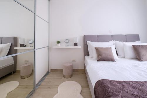 a bedroom with a large bed and a mirror at MB Luxury Apartments in Zadar