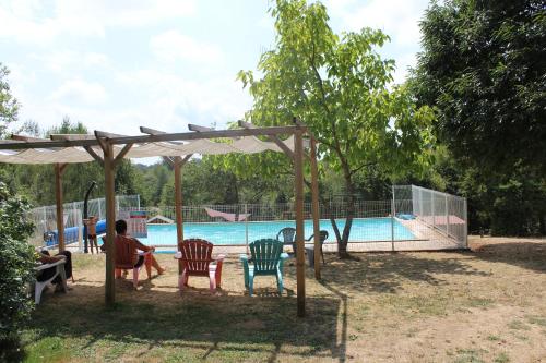 a group of people sitting in chairs in front of a pool at Camping de la Bucherie in Saint-Saud-Lacoussière