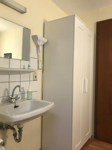 a bathroom with a sink and a white cabinet at Hotel Garni Elisabeth in Göppingen