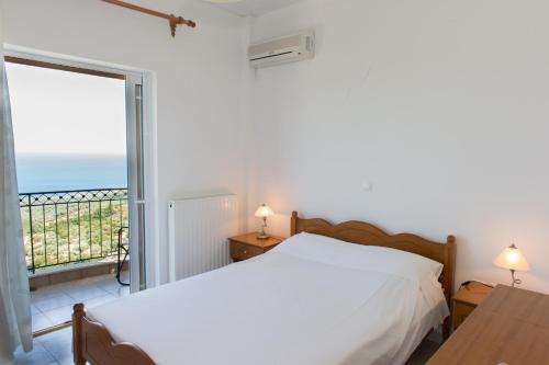 a bedroom with two beds and a balcony with the ocean at Mathia Apartments in Mathía
