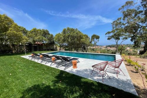 a swimming pool with a group of chairs next to it at Villa Ita - 7 Room villa & Pool - Sintra in Colares