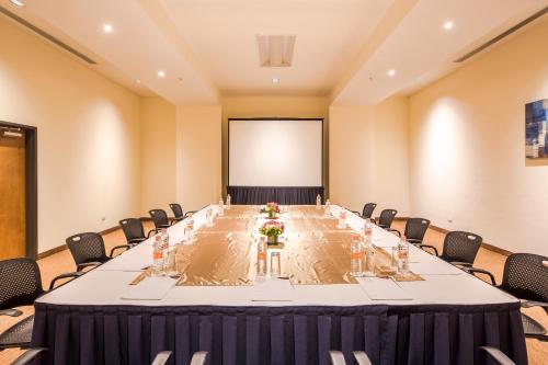 a long table in a room with chairs and a screen at Crowne Plaza Monterrey Aeropuerto by IHG in Monterrey