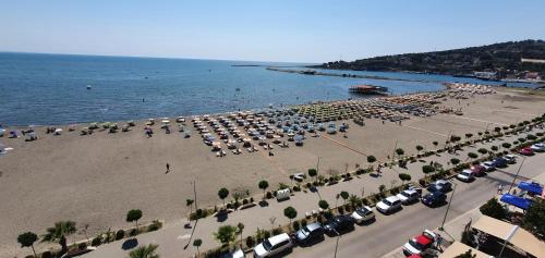 a beach with a lot of cars and umbrellas at Sunset Apartment in Shëngjin