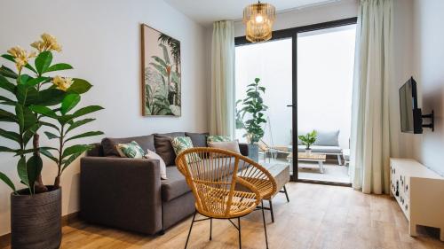 a living room with a couch and a chair at Magno Apartments Alameda 1851 - Shared jacuzzi in Seville