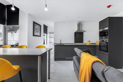 a kitchen with a table and some yellow chairs at Winter Garden Apartments by Sasco in Blackpool