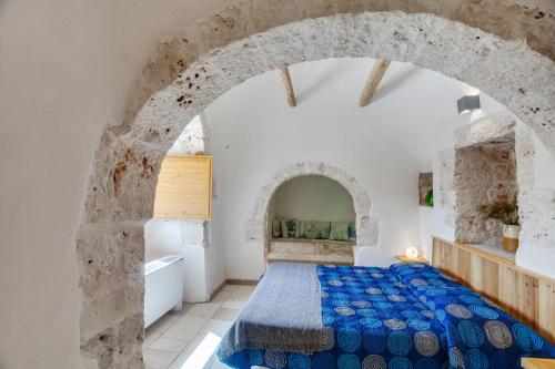 ein Schlafzimmer mit einem Bett und einem Torbogen in der Unterkunft TRUeLLOVE Wonderful Trullo in Putignano in Putignano