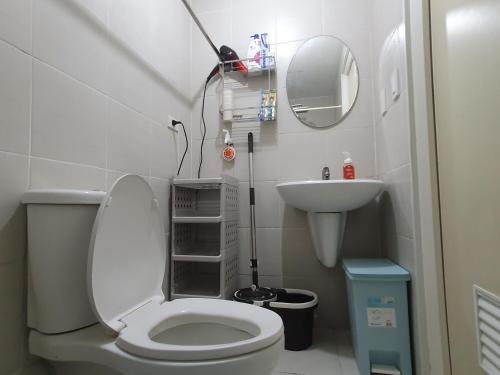 een kleine badkamer met een toilet en een wastafel bij Mint Homes in Jazz Residences Tower B in Manilla