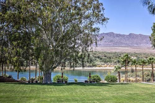 a tree in the middle of a field with a lake at Amenity-Packed Home with Hot Tub and River Views! in Bullhead City