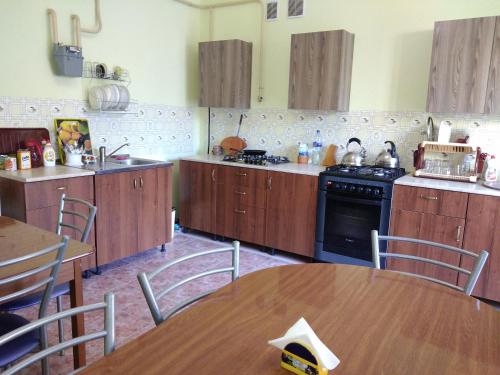 a kitchen with wooden cabinets and a table and chairs at Гостевой дом Радужный in Vityazevo