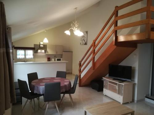 - un salon avec une table à manger et un escalier dans l'établissement Gîte de la Forêt, à Paray-le-Monial