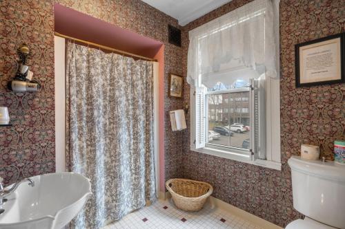 a bathroom with a toilet and a sink and a window at Lizzie Borden House in Fall River