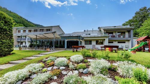 een huis met een tuin en een speeltuin bij Hotel Bystrá in Brezno