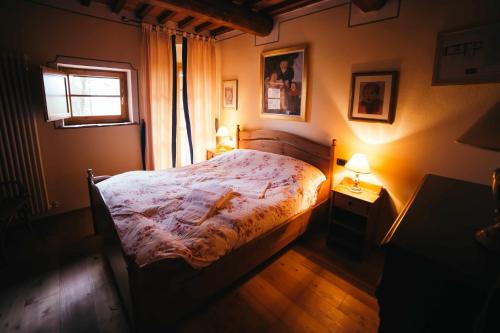 a bedroom with a bed and a window and two lamps at Borgo 7 TigliAppartamento a Montepulciano n1 in Montepulciano