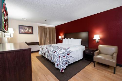 Habitación de hotel con cama y silla en Red Roof Inn Chicago-OHare Airport Arlington Hts, en Arlington Heights