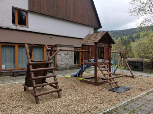 a playground with two swings and a wooden play set at Parkhotel Harrachov in Harrachov