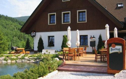 a house with a table and chairs in front of it at Pension Fontana in Špindlerův Mlýn