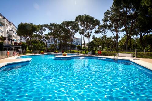 duży basen z niebieską wodą w obiekcie MARBELLA BANUS SUITES - Bird Of Paradise Playas del Duque Banús Suite Apartment w Marbelli