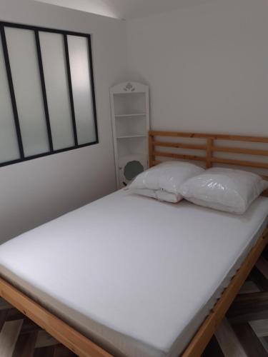 1 cama con 2 almohadas en una habitación en Charmante petite maison à St Aygulf, en Saint-Aygulf