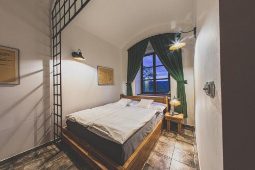 a bedroom with a bed in a room with a window at Penzion Šatlava in Nové Město nad Metují