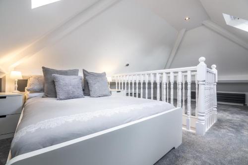 een witte slaapkamer met een wit bed met kussens bij Mayfield House - 4 Bedroom House - Tenby in Tenby