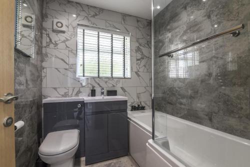 een badkamer met een toilet, een bad en een wastafel bij Mayfield House - 4 Bedroom House - Tenby in Tenby