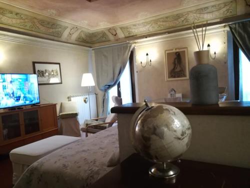 a bedroom with a globe on a table and a television at Loft ‘900 in Ravenna