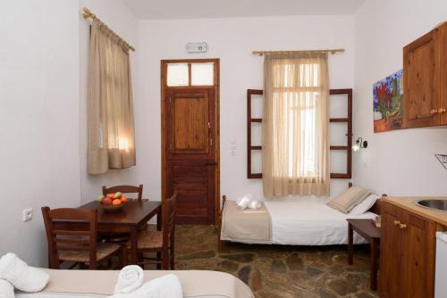 a room with two beds and a table and a kitchen at Uranos Studios in Amorgos