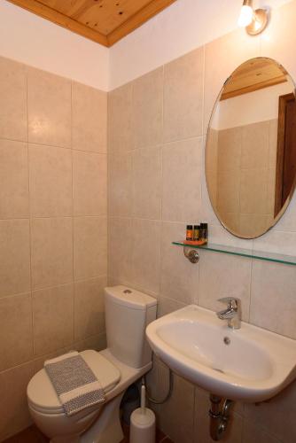 a bathroom with a sink and a toilet and a mirror at Uranos Studios in Amorgos