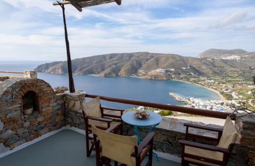 a balcony with a table and chairs and a view of the ocean at Uranos Studios in Amorgos