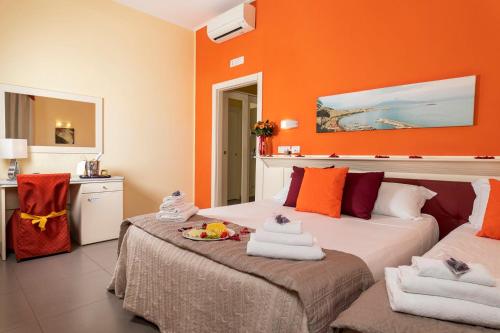 two beds in a room with orange walls at Capodichino International Hotel in Naples