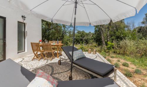 a patio with an umbrella and a table and chairs at Quinta de São Pedro in Sobreda