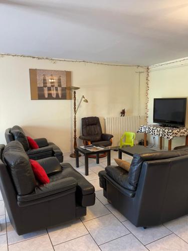 a living room with leather furniture and a flat screen tv at la ferme de Martine in Lent