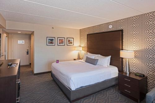 Habitación de hotel con cama grande y escritorio. en Crowne Plaza Suites MSP Airport en Bloomington