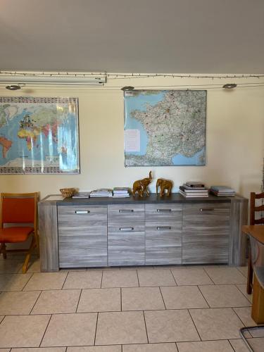 a large wooden cabinet in a room with a map on the wall at la ferme de Martine in Lent