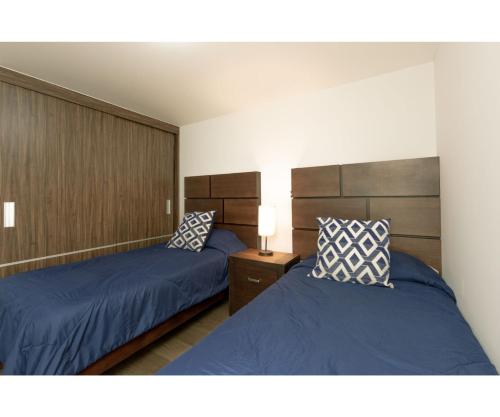- 2 lits dans une chambre avec des draps et des oreillers bleus dans l'établissement Exclusivity, Comfort & Elegance in La Narvarte - Vertiz, à Mexico
