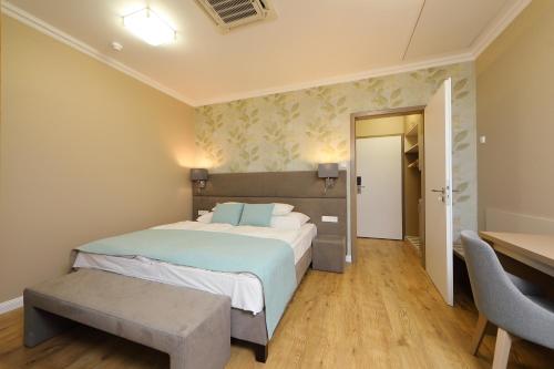 a bedroom with a large bed and a desk at Hotel Blaha Lujza in Balatonfüred