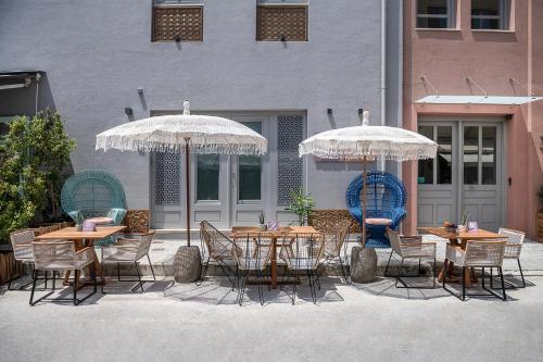 a group of tables and chairs under umbrellas at Nyx Chic Manor in Chania Town