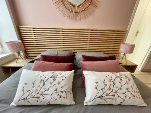 Un dormitorio con una cama con almohadas encima. en Le Cocon, en Bayeux
