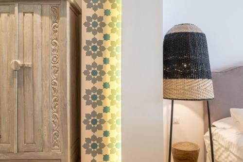 a bedroom with a lamp and a wall with green tiles at Nyx Chic Manor in Chania Town