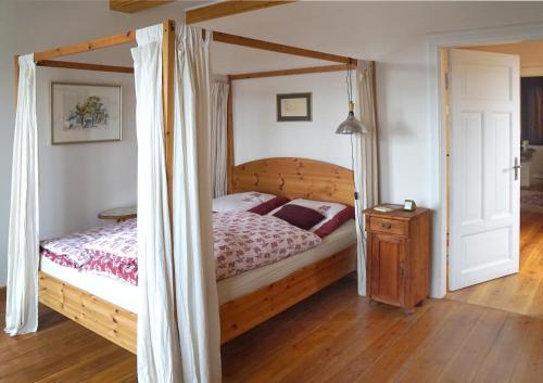 a bedroom with a wooden bed with a canopy at Gästehaus Kibbel in Bosau