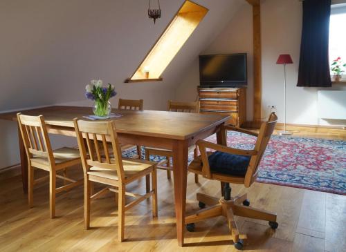 a dining room with a wooden table and chairs at Gästehaus Kibbel in Bosau