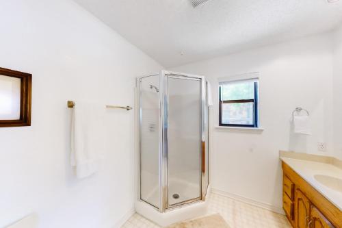 a white bathroom with a shower and a sink at River Oaks R&R in Kingsland