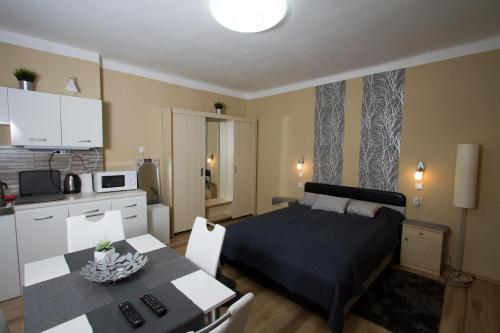 1 dormitorio con cama, mesa y cocina en Angyal apartman, en Cserkeszőlő