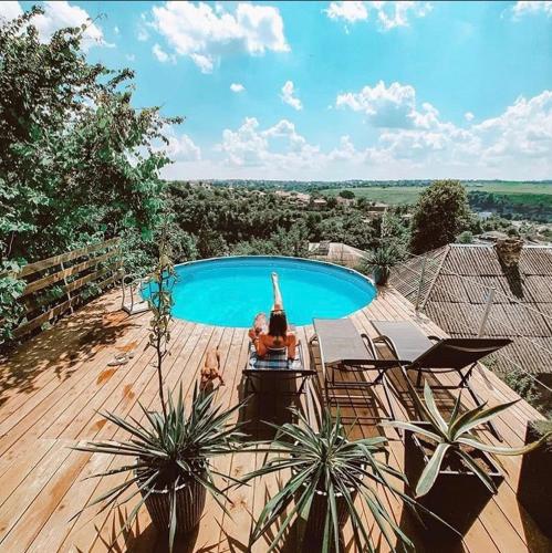 two people laying in a swimming pool on a wooden deck at Tatsopus in Kamianets-Podilskyi
