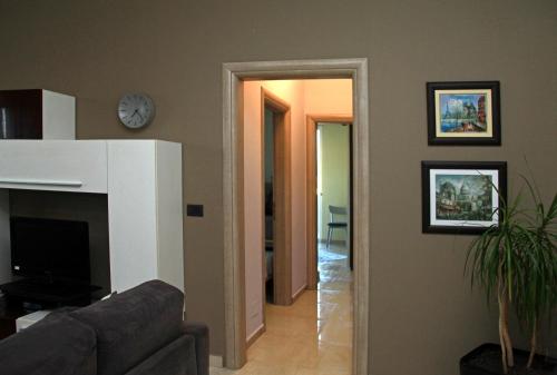 a living room with a couch and a clock on the wall at Main square apartment in Durrës