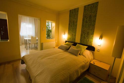 a bedroom with a large bed with yellow walls at Angyal apartman in Cserkeszőlő