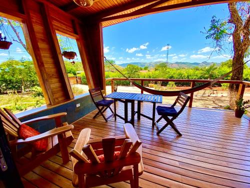 eine Holzterrasse mit einem Tisch und Stühlen darauf in der Unterkunft Hoja Azul in Hojancha